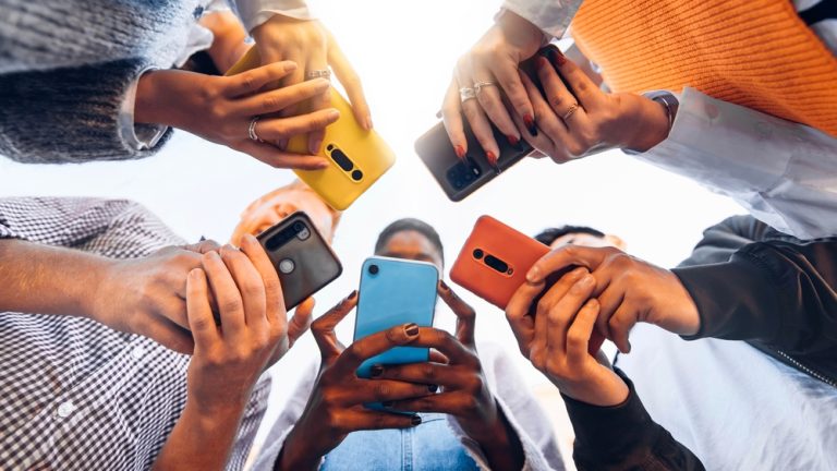 Teens,In,Circle,Holding,Smart,Mobile,Phones,-,Multicultural,Young