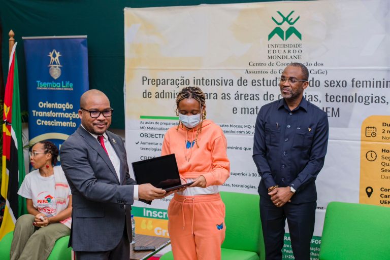 Reitor entrega laptop a uma das alunas beneficiarias